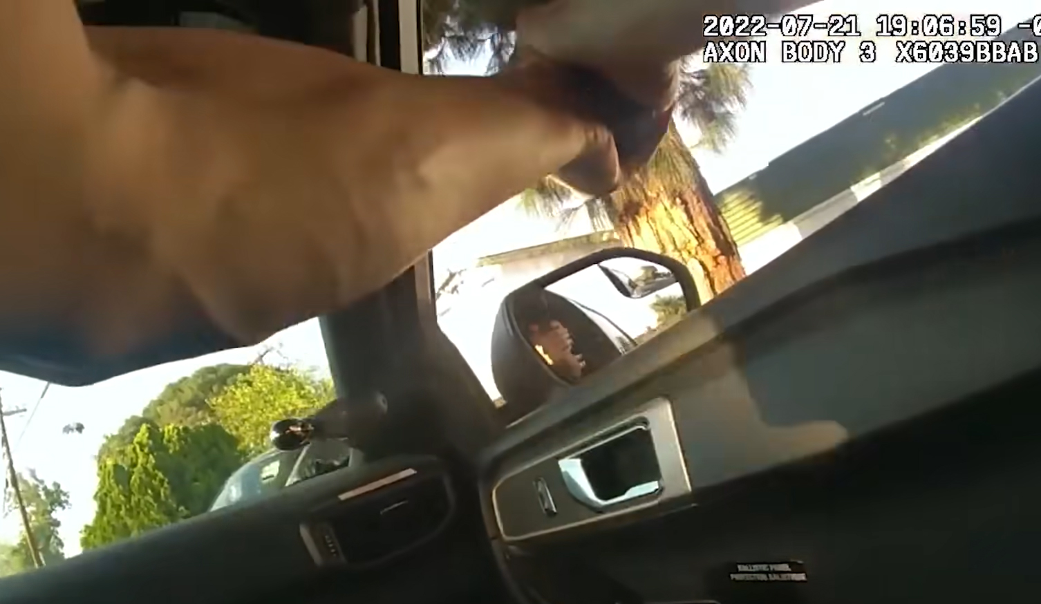 Police body camera video shows an LAPD officer firing his weapon at an unarmed suspect while inside a moving patrol vehicle. (Source: Screenshot - YouTube)
